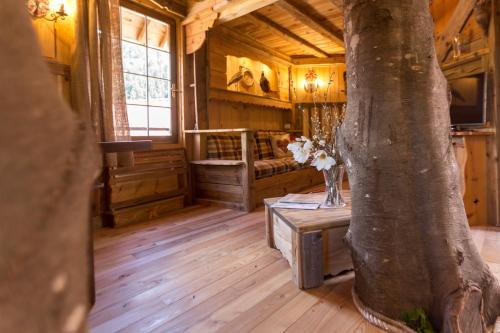 a room with a tree and a bed in a cabin at Dolomiti Village in Comeglians
