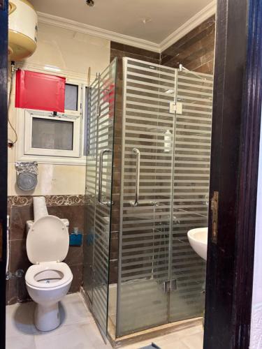 a bathroom with a shower and a toilet and a sink at Makramia Condo in Madinaty in Madinaty