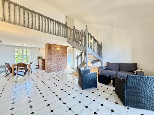 un salon avec un canapé et un escalier dans l'établissement Grand Duplex - Terrasse Vue Mer, à Carqueiranne