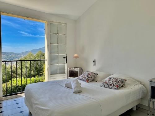 - une chambre avec un grand lit blanc et une grande fenêtre dans l'établissement Grand Duplex - Terrasse Vue Mer, à Carqueiranne