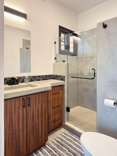 a bathroom with a shower and a sink and a toilet at 2 Casas and Pool- Walk to Beach, Great for Groups in El Pescadero
