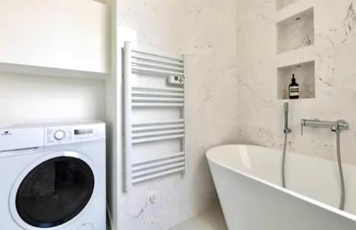 - un lave-linge dans la salle de bains à côté d'une baignoire dans l'établissement Appartement 2 pieces Boulogne-Billancourt, à Boulogne-Billancourt