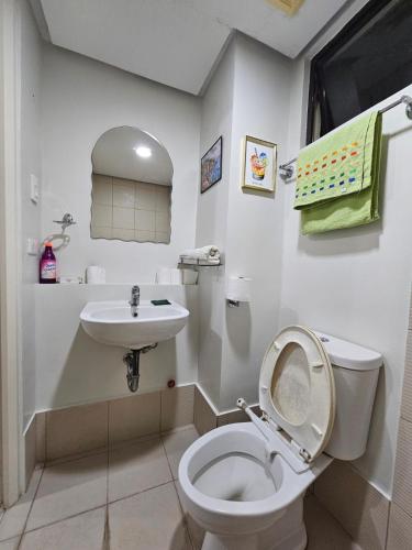 a white bathroom with a toilet and a sink at Pine suite Condo Tagaytay in Tagaytay