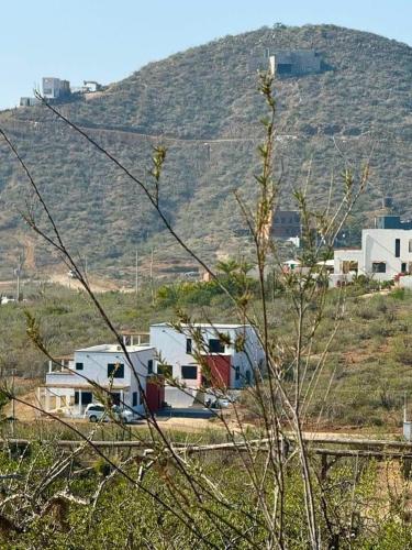 a group of houses in a field with a hill at 2 Casas and Pool- Walk to Beach, Great for Groups in El Pescadero