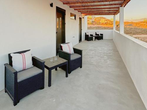 a balcony with chairs and a table with a view at 2 Casas and Pool- Walk to Beach, Great for Groups in El Pescadero