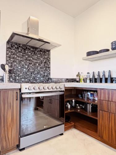 a kitchen with a stainless steel stove top oven at 2 Casas and Pool- Walk to Beach, Great for Groups in El Pescadero