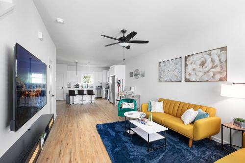a living room with a yellow couch and a tv at Perfect Getaway Prime Location Game Room And HotTub in Charlotte