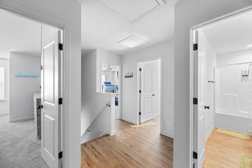 an empty room with white walls and wood floors at Perfect Getaway Prime Location Game Room And HotTub in Charlotte