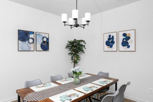 a dining room with a table and a chandelier at Perfect Getaway Prime Location Game Room And HotTub in Charlotte