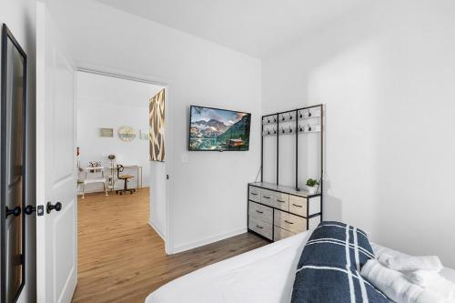 a white bedroom with a bed and a dresser at Perfect Getaway Prime Location Game Room And HotTub in Charlotte