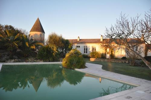 a house with a swimming pool in front of a house at Le Moulin de la Borderie in Saint-Pierre-dʼOléron