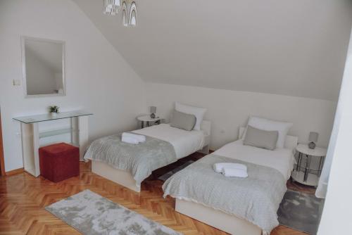 a room with two beds and a table with a mirror at Apartman Nina in Ðakovo