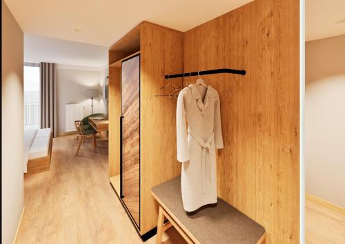 a room with a wooden wall with a robe on a table at Gasthof Hummel Hotel in Stammham