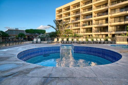 a swimming pool in front of a hotel at Sugar Beach 502 in Kihei