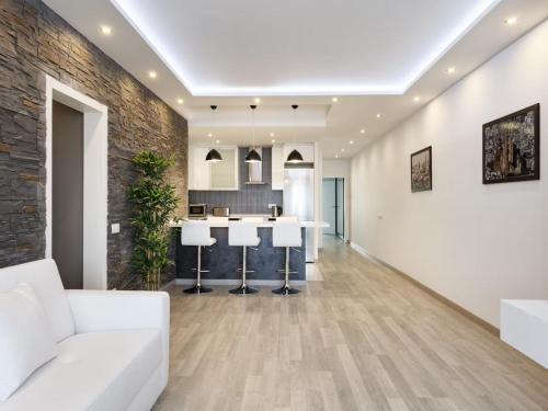 Il comprend un salon doté d'un mobilier blanc et d'un mur en briques. dans l'établissement Maison en Villefranche pour les tourists, à Villefranche-sur-Mer