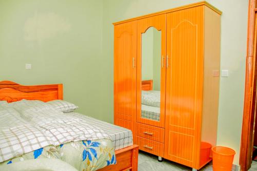 - une chambre avec une armoire en bois et un lit dans l'établissement Number Seven apartment, à Kigali