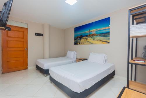 a hotel room with two beds and a door at Hotel Tropical San Jeronimo in San Jerónimo
