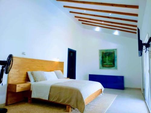 ein Schlafzimmer mit einem Bett in einem weißen Raum in der Unterkunft Villa Saphir a Nianing in Nianing
