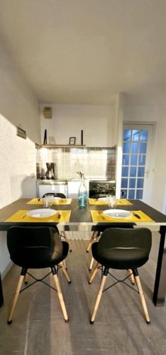 une cuisine avec une table et des chaises dans une pièce dans l'établissement Face Mer, à Fort-Mahon-Plage