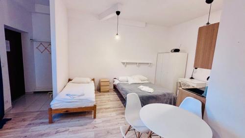 a small room with two beds and a table and chairs at Gościniec i Restauracja Salton in Bochnia
