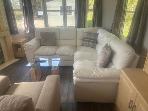 a living room with a white couch and a table at Southview cedar bank 6 in Skegness