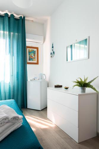 a bedroom with a bed and a white dresser at Mondello House Eraclea in Mondello