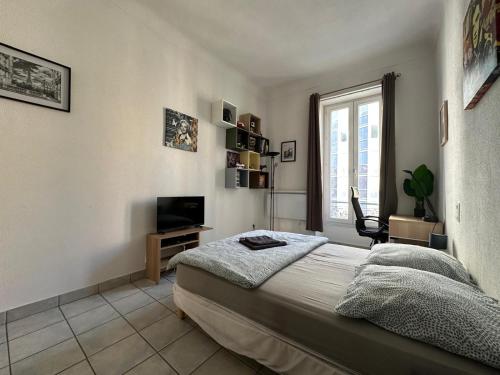 une chambre avec un lit, une télévision et une fenêtre dans l'établissement Appartement Centre Ville de Nice, à Nice