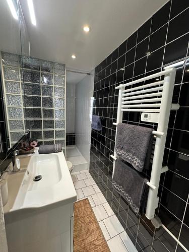 La salle de bains est pourvue d'un lavabo blanc et de carrelage noir. dans l'établissement Appartement Centre Ville de Nice, à Nice