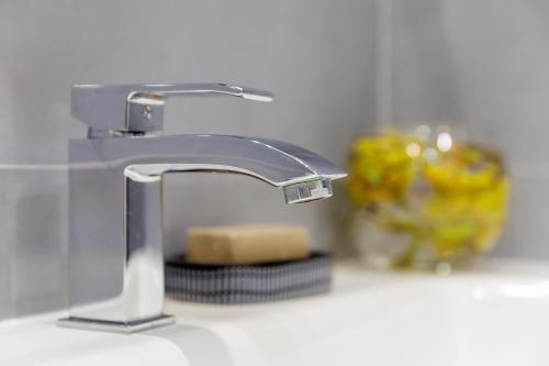 a bathroom sink with a faucet and a block of cheese at Genoa Lux Apartments with parking in Genova