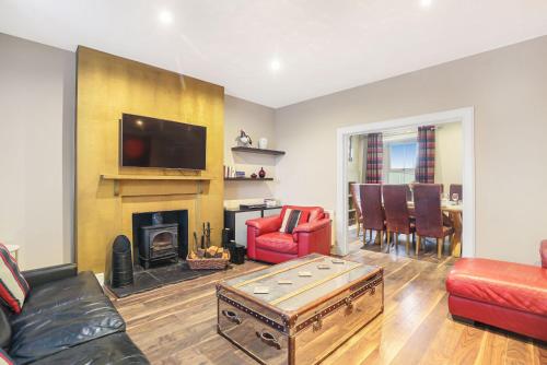 a living room with a fireplace and a tv at Grove Cottage - North East Escapes in Bamburgh
