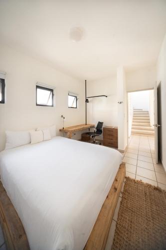 a bedroom with a large white bed and a desk at Grand Villa with Private Patio & Parking by Tasman in San José del Cabo