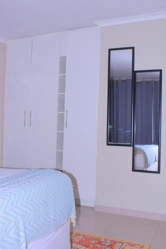 a bedroom with a bed and a mirror on the wall at Gwanxhae Boutique Accommodation in Maun