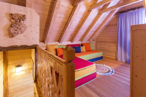 a room with a bed in a wooden cabin at Dolomiti Village in Comeglians