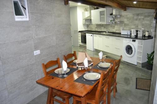 a dining room with a wooden table and chairs at O Chalé Bela in Setúbal