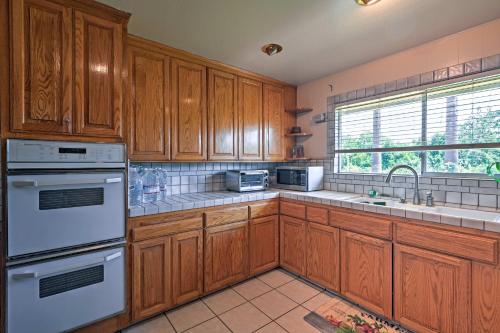 a kitchen with wooden cabinets and white appliances at Gilroy Home with Deck on 20 Acres, 7 Mi to Downtown! in Gilroy