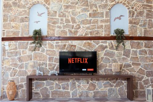 a laptop sitting on a table in front of a stone wall at Mnēmes Residence in Sozopoli