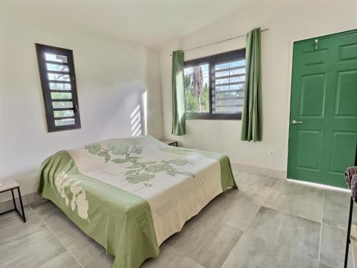 a bedroom with a bed and a green door at Tahiti Iti - Fare Pihiti Spot in Paui