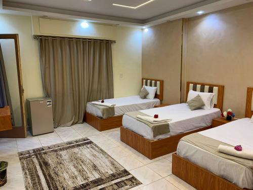 カイロにあるGarden City inn Hotelの赤いキャンドルが付いたベッド2台が備わるホテルルームです。