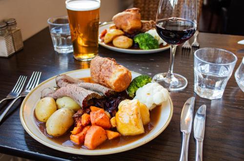 a table with two plates of food and a glass of wine at The Bandstand in Nairn