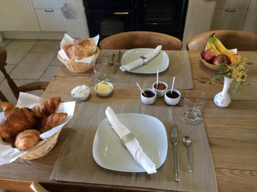 a table with plates of food and bread on it at Les Glycines in Saint-Gaudens