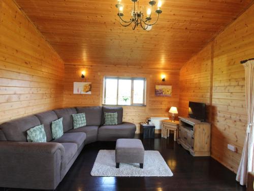 a living room with a couch and a television at Cherry Lodge in Bodmin