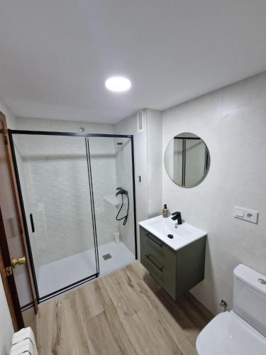 a bathroom with a shower and a sink and a mirror at Mirador la Jardinera- céntrico con parking privado GRATIS in Teruel