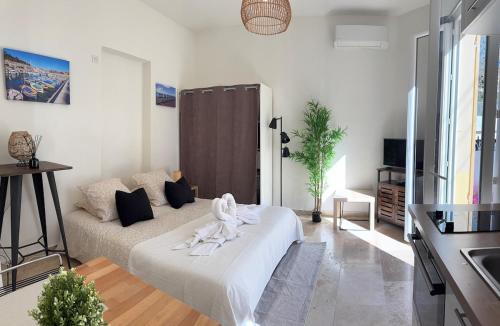 un salon blanc avec un canapé et une table dans l'établissement Studio cosy, terrasse, proche Mer et tramway, à Nice