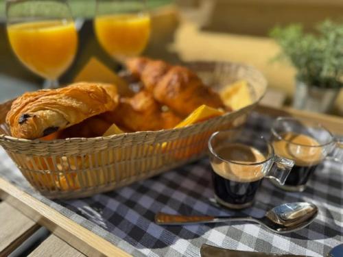 - un panier de croissants et de jus d'orange sur une table dans l'établissement Studio cosy, terrasse, proche Mer et tramway, à Nice