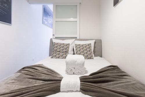 - une chambre avec un lit, des serviettes et des oreillers dans l'établissement Les Serbes - 6mn du Palais&Plage, centre, charmant, à Cannes