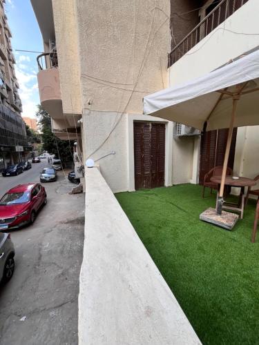 a building with a yard of green grass on the side of it at Triple Garden Studios and apartments in Cairo