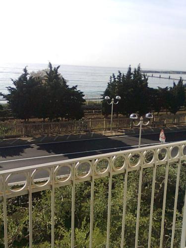 a white fence with the ocean in the background at Residence Villa Carmen fronte mare a 50 mt in Pietra Ligure