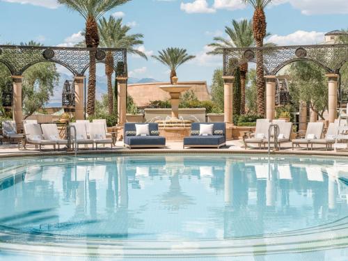 a swimming pool with chairs and a fountain at The Palazzo at The Venetian® in Las Vegas