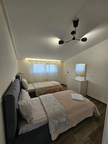 シュコダルにあるLa Casa di Fatmirのベッド2台とソファのある寝室