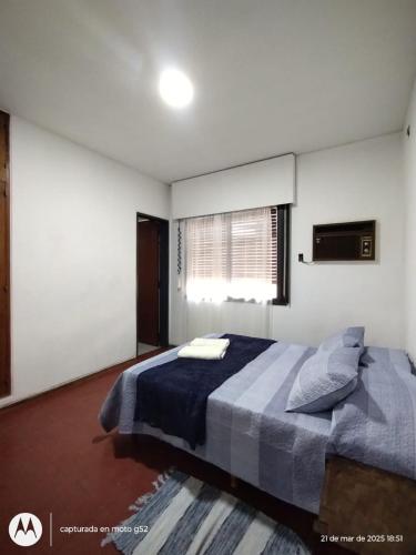 a bedroom with a bed with a blue blanket and a window at Urbano B&B 2A in San Juan
